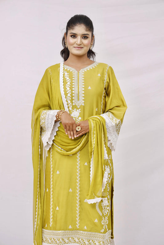 The outfit is a mustard yellow color with white embroidery and lace detailing.