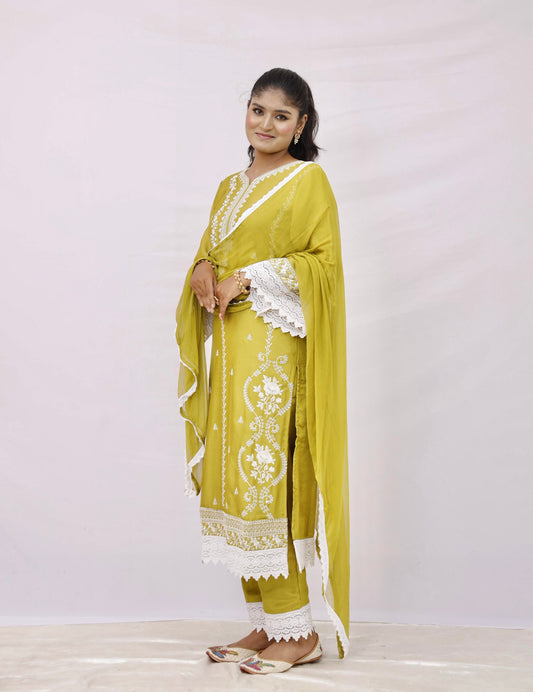 The outfit is a mustard yellow color with white embroidery and lace detailing.