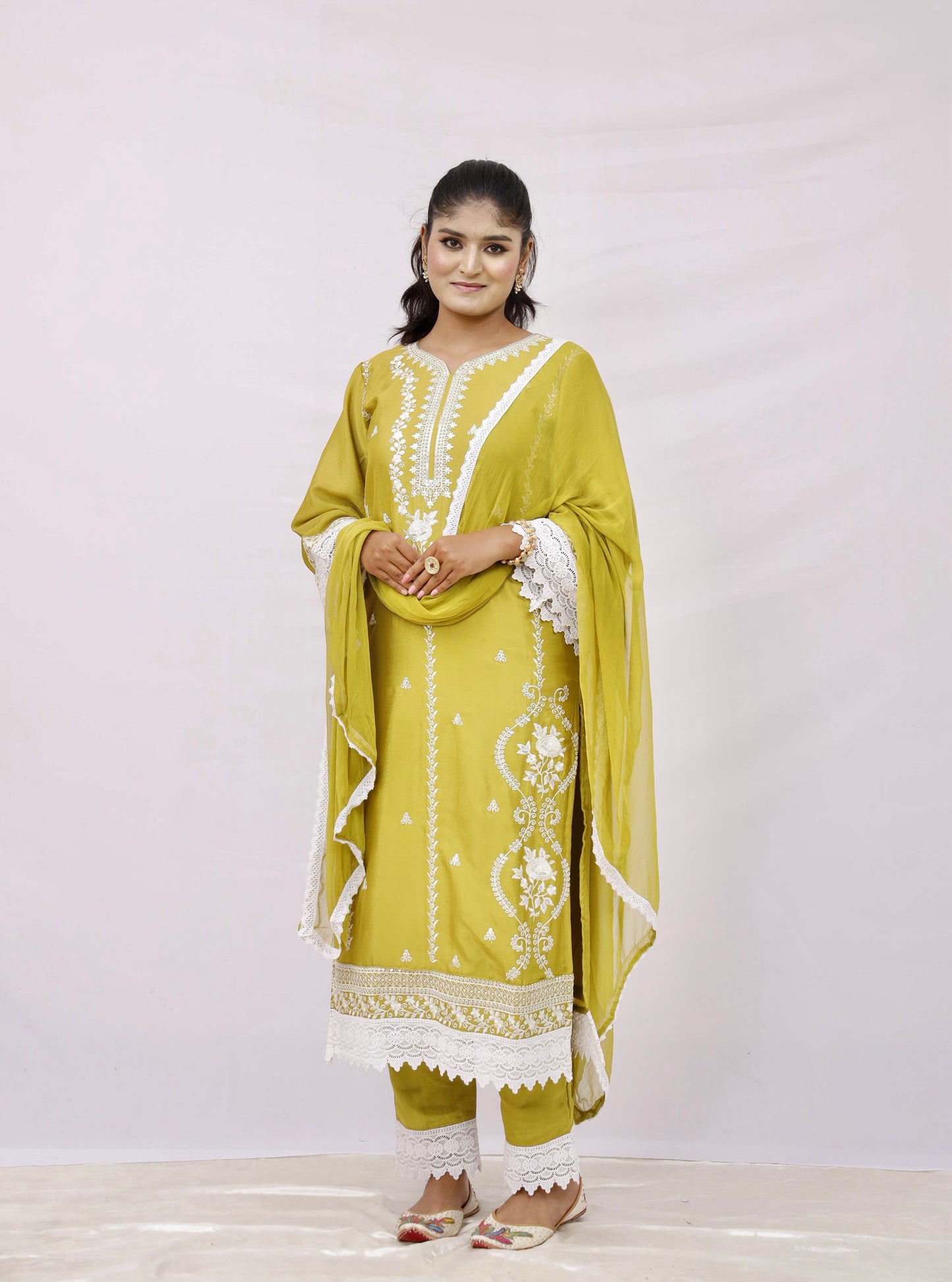 The outfit is a mustard yellow color with white embroidery and lace detailing.