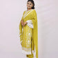 The outfit is a mustard yellow color with white embroidery and lace detailing.